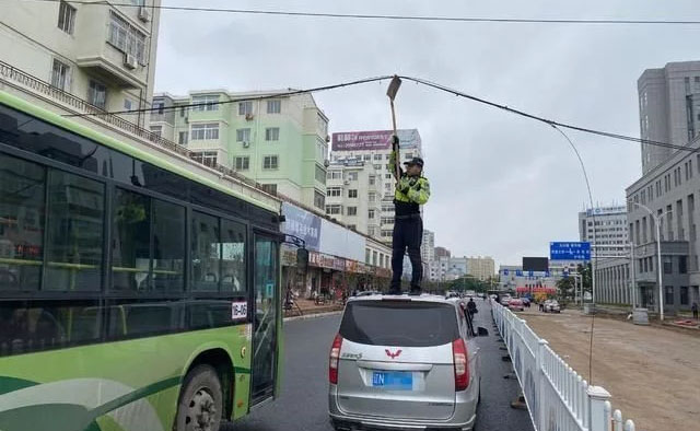 电缆线成“拦路虎” 朝阳交警变身“托举哥”